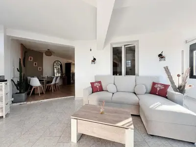 a living room with a couch and a table at Appartement T3 vue mer et coucher de soleil sur les Îles Sanguinaires - climatisé in Pietrosella