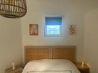 a bedroom with a bed and a window at Appartement T3 vue mer et coucher de soleil sur les Îles Sanguinaires - climatisé in Pietrosella