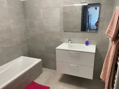 a bathroom with a sink and a tub and a mirror at appartement ajaccio in Ajaccio