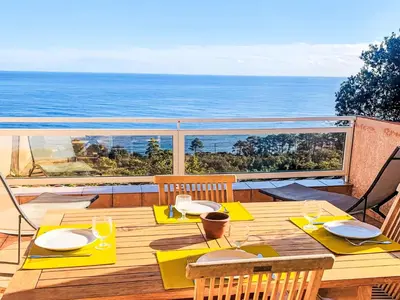 a wooden table on a deck with a view of the ocean at Holiday Home Casa Orsoni 80m² by Interhome in Cannella