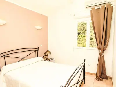 a white bedroom with a bed and a window at Holiday Home Casa Orsoni 80m² by Interhome in Cannella