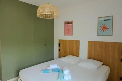 a bedroom with two beds and a chandelier at Villa Cime Di Machja in Sainte-Lucie de Porto-Vecchio