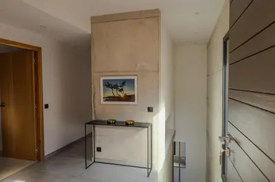 a hallway with a table and a wall with a painting at Villa Cime Di Machja in Sainte-Lucie de Porto-Vecchio