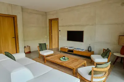 a living room with a couch and a tv at Villa Cime Di Machja in Sainte-Lucie de Porto-Vecchio