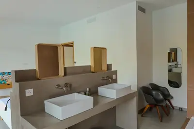 a bathroom with two sinks and two mirrors at Villa Cime Di Machja in Sainte-Lucie de Porto-Vecchio