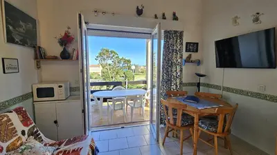 a living room with a door open to a balcony at CYRNEA 27- Plage à pieds - Clim-Wifi- Favone in Conca