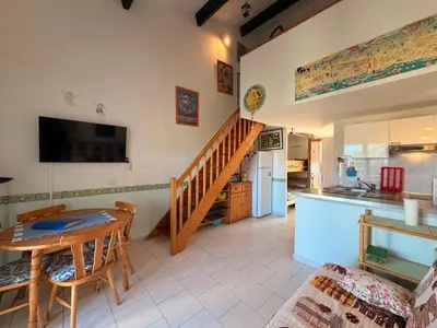 a kitchen and a dining room with a table and a kitchen gmaxwell gmaxwell gmaxwell gmaxwell at CYRNEA 27- Plage à pieds - Clim-Wifi- Favone in Conca