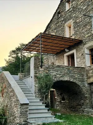 a stone building with stairs and a wooden roof at Village House With Character In Corsica in Scolca