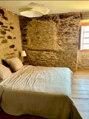 a bedroom with a bed with a stone wall at Village House With Character In Corsica in Scolca