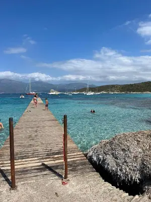 a group of people walking on a pier in the water at bel appartement vue montagne proche bastia in Borgo
