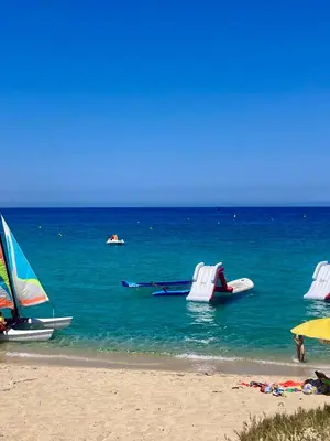 a beach with chairs and boats in the water at bel appartement vue montagne proche bastia in Borgo