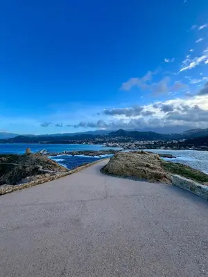 a road next to a body of water at bel appartement vue montagne proche bastia in Borgo