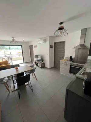 a large kitchen with a table and a dining room at bel appartement vue montagne proche bastia in Borgo