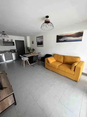 a living room with a couch and a table at bel appartement vue montagne proche bastia in Borgo