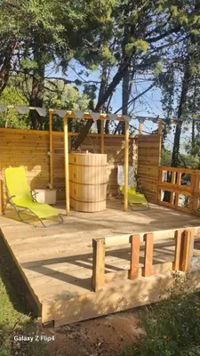 a small room with a bed in a log cabin at Cabane Sauna & Jacuzzi Hiver in Vaccili
