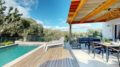 a patio with a table and chairs and a pool at Villa With Pool Between Porto-Vecchio And Bonifacio in Sotta