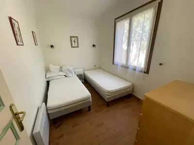a small room with two beds and a window at Maison Bon Aria familiale vue mer 5 min plages in Porto-Vecchio