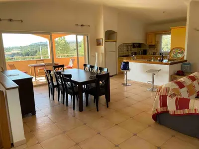 a kitchen and dining room with a table and chairs at Maison Bon Aria familiale vue mer 5 min plages in Porto-Vecchio