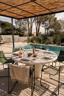 a person sitting on a chair next to a swimming pool at Résidence A Me Vita - Villas avec piscine privée à Porto-Vecchio in San-Gavino-di-Carbini