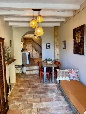 a living room with a table and a dining room at Magnifique Duplex au coeur de Cargèse in Cargèse