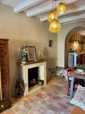 a living room with a fireplace and a table at Magnifique Duplex au coeur de Cargèse in Cargèse
