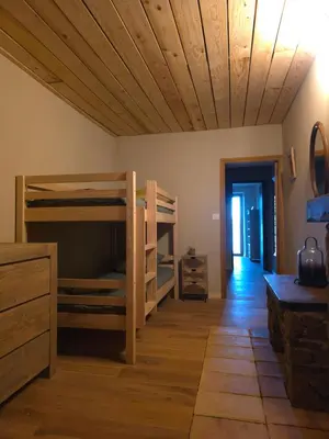 a room with bunk beds and a wooden ceiling at Magnifique Duplex au coeur de Cargèse in Cargèse