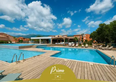 a pool at a resort with chairs and a building at U Bellu - Modernité et calme à deux pas de la mer in Lecci