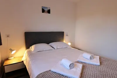 a bedroom with a large bed with towels on it at U Bellu - Modernité et calme à deux pas de la mer in Lecci