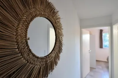 a mirror hanging on a wall in a hallway at U Bellu - Modernité et calme à deux pas de la mer in Lecci