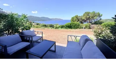 a patio with couches and a view of the water at APPARTEMENT Vue MER TIUCCIA in Casaglione