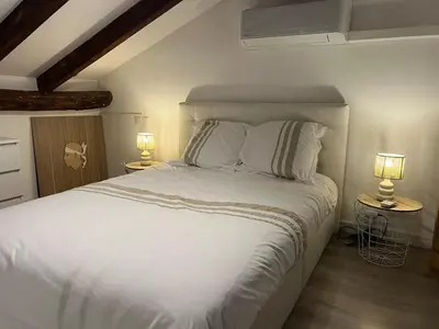 a bedroom with a white bed with two lamps at APPARTEMENT Vue MER TIUCCIA in Casaglione