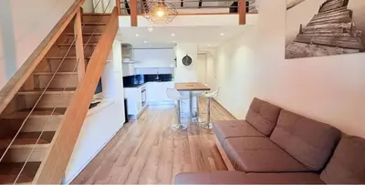 a living room with a couch and a kitchen at APPARTEMENT Vue MER TIUCCIA in Casaglione