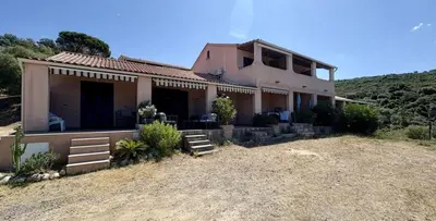 a house on top of a hill with a yard at APPARTEMENT Vue MER TIUCCIA in Casaglione