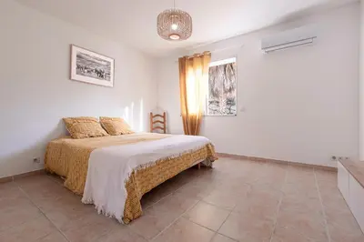 a bedroom with a bed and a chair in it at Villa Valle Pace Maria - Piscine Privée in Afa