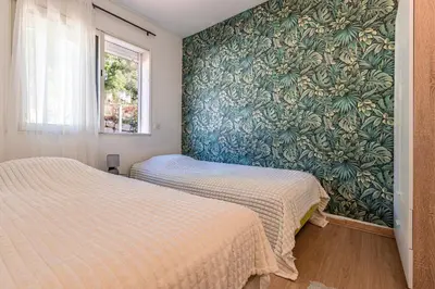 two beds in a room with a wall mural at Villa Valle Pace Maria - Piscine Privée in Afa