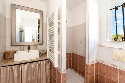 a bathroom with a sink and a mirror at Villa Valle Pace Maria - Piscine Privée in Afa