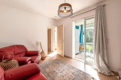 a living room with a red couch and a chair at Villa Valle Pace Maria - Piscine Privée in Afa