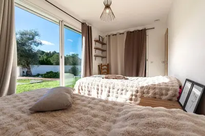 a bedroom with two beds and a large window at Villa Valle Pace Maria - Piscine Privée in Afa