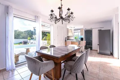 a dining room with a table and chairs at Villa Valle Pace Maria - Piscine Privée in Afa