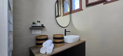 a bathroom with a sink and a mirror at Maison de Charme Vue Exceptionnelle Mer & Montagne in Campomoro