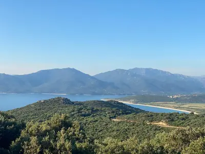 a view of a lake with mountains in the background at Maison de Charme Vue Exceptionnelle Mer & Montagne in Campomoro