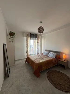 a bedroom with a bed and a large window at Cherry & Mountain Appartement in Ajaccio