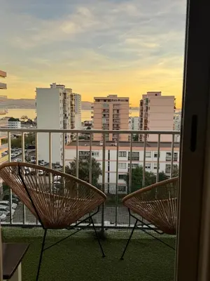 a balcony with two chairs and a view of a city at Cherry & Mountain Appartement in Ajaccio