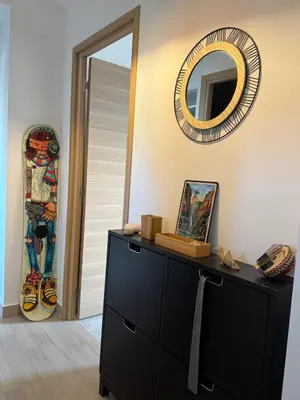 a dresser in a room with a mirror and a skateboard at Cherry & Mountain Appartement in Ajaccio