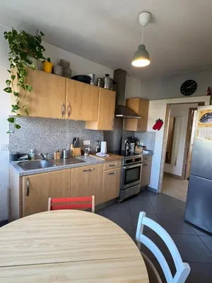 a kitchen with wooden cabinets and a table with a tableablish at Cherry & Mountain Appartement in Ajaccio