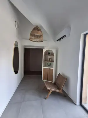 a living room with a chair and a shelf at T2 cozy terrasse 40 m2 et pergola in Pianottoli-Caldarello