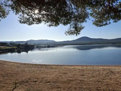a view of a lake with mountains in the background at T2 cozy terrasse 40 m2 et pergola in Pianottoli-Caldarello