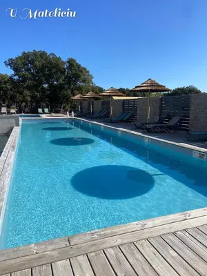 a large swimming pool with blue water at logement piscine Porto Vecchio U Mateliciu in Lecci