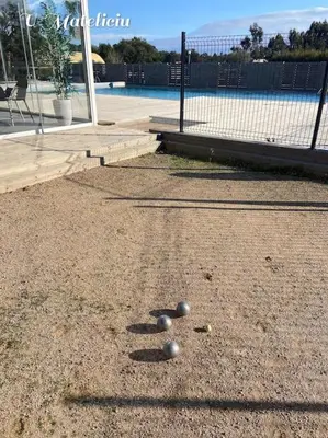 a group of balls on the ground near a tennis court at logement piscine Porto Vecchio U Mateliciu in Lecci