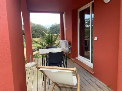 a porch with a table and chairs and a window at logement piscine Porto Vecchio U Mateliciu in Lecci